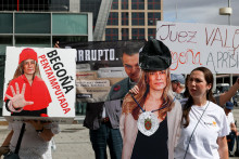 Protestujúci stojí vedľa výrezu zobrazujúceho Begonu Gomezovú, manželku španielskeho premiéra Pedra Sáncheza, pred súdom, kde Gomezová predstupuje pred sudcu. FOTO: Reuters