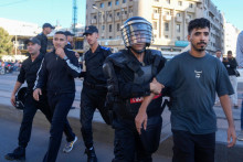 Na snímke policajti zadržujú demonštrantov počas protestu v marockej Casablance. FOTO: TASR/AP