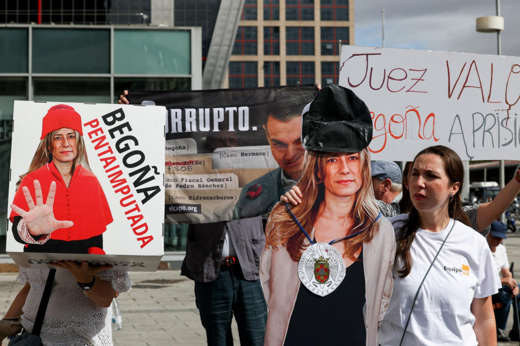 Protestujúci stojí vedľa výrezu zobrazujúceho Begonu Gomezovú, manželku španielskeho premiéra Pedra Sáncheza, pred súdom, kde Gomezová predstupuje pred sudcu. FOTO: Reuters
