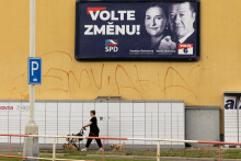 Žena prechádza okolo volebného plagátu lídra strany Sloboda a priama demokracia (SPD) Tomia Okamuru. FOTO: REUTERS