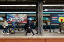 Cestujúci prechádzajú okolo volebného plagátu českého lídra strany ANO a bývalého českého premiéra Andreja Babiša. FOTO: Reuters