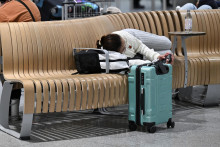 Žena odpočíva na letisku v Mníchove po tom, čo boli obe pristávacie dráhy na letisku v Mníchove uzavreté už druhýkrát za menej ako 24 hodín. FOTO: Reuters