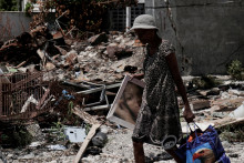 Obyvateľka sa vracia do štvrte Route de Nazon po tom, čo vodca gangu Jimmy „Barbeque“ Cherizier stiahol svojich vojakov z niekoľkých štvrtí v severovýchodnom Port-au-Prince a vyzval bývalých obyvateľov, aby sa vrátili do svojich domovov. FOTO: Reuters