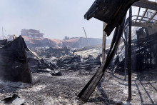 Dym stúpa zo spáleného nákupného centra, ktoré bolo vyplienené počas protestov proti častým výpadkom prúdu a nedostatku vody v Antananarive na Madagaskare. FOTO: Reuters