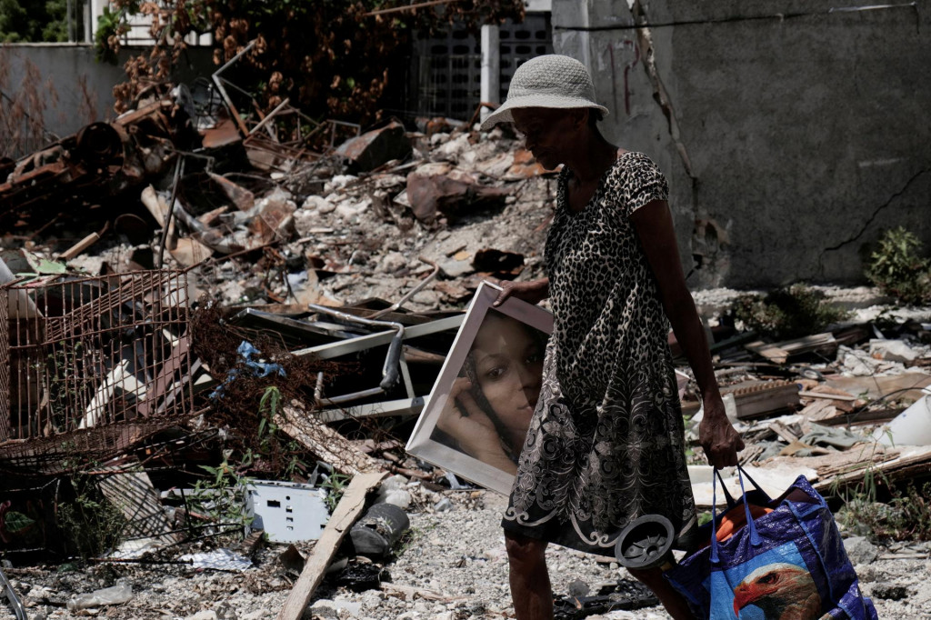 Obyvateľka sa vracia do štvrte Route de Nazon po tom, čo vodca gangu Jimmy „Barbeque“ Cherizier stiahol svojich vojakov z niekoľkých štvrtí v severovýchodnom Port-au-Prince a vyzval bývalých obyvateľov, aby sa vrátili do svojich domovov. FOTO: Reuters