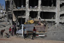 Vysídlení Palestínčania, ktorí vracajú do svojich domovov, kráčajú okolo zničených budov v meste Gaza. FOTO: TASR/AP