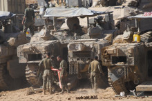 Izraelskí vojaci pracujú na svojich tankoch v hangári neďaleko hranice Izraela s Pásmom Gazy. FOTO: TASR/AP
