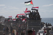 Vysídlení Palestínčania jazdia na nákladných autách naloženými svojimi osobnými vecami a mávajú egyptskými a palestínskymi zástavami na ceste pri pobreží neďaleko Wadi Gazy, v centrálnom Pásme Gazy v sobotu 11. októbra 2025 smerom do mesta Gaza. FOTO TASR/AP