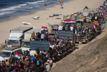 Vysídlení Palestínčania jazdia na nákladných autách naloženými svojimi osobnými vecami a mávajú egyptskými a palestínskymi zástavami na ceste pri pobreží neďaleko Wadi Gazy, v centrálnom Pásme Gazy v sobotu 11. októbra 2025 smerom do mesta Gaza. FOTO: TASR/AP
