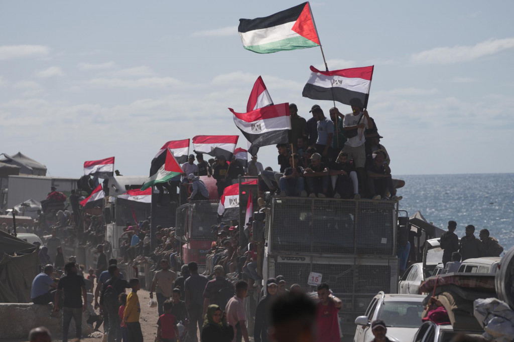 Vysídlení Palestínčania jazdia na nákladných autách naloženými svojimi osobnými vecami a mávajú egyptskými a palestínskymi zástavami na ceste pri pobreží neďaleko Wadi Gazy, v centrálnom Pásme Gazy v sobotu 11. októbra 2025 smerom do mesta Gaza. FOTO TASR/AP