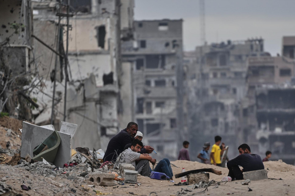 Vysídlení Palestínčania sedia pri troskách svojich zničených domov v utečeneckom tábore Shati. FOTO: TASR/AP
