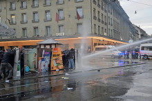 Propalestínskych demonštrantov postrekuje vodný kaňon počas demonštrácie v Berne. FOTO: Reuters/Raimond Lueppken