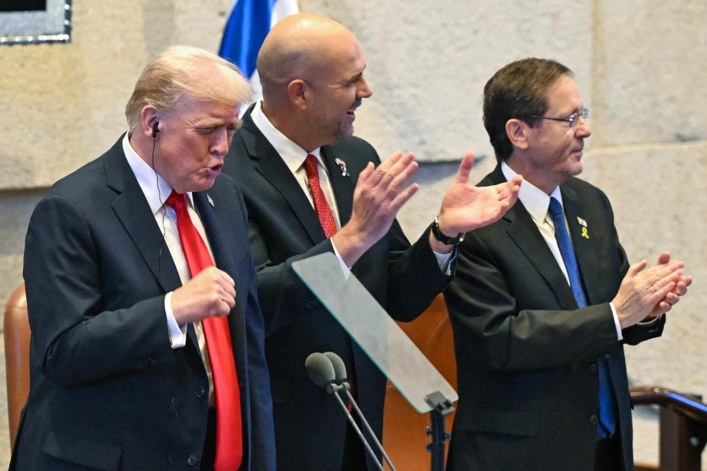 Americký prezident Donald Trump, predseda izraelského parlamentu (Knesetu) Amir Ohana a izraelský prezident Jicchak Herzog tlieskajú na počesť Trumpa pred jeho prejavom v Knesete v Jeruzaleme. FOTO: TASR/AP