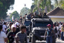Vojská verné veliteľovi vojenskej jednotky CAPSAT plukovníkovi Michaelovi Randrianirinovi smerujú k prezidentskému palácu, aby oznámili, že ozbrojené sily preberajú kontrolu nad krajinou v Antananarive na Madagaskare. FOTO: TASR/AP