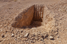 Jeden svedok agentúre Reuters povedal, že bol vykopaný nedokončený zákop na uloženie tiel v tomto masovom hrobe v púšti neďaleko východosýrskeho mesta Dhumair. FOTO: REUTERS