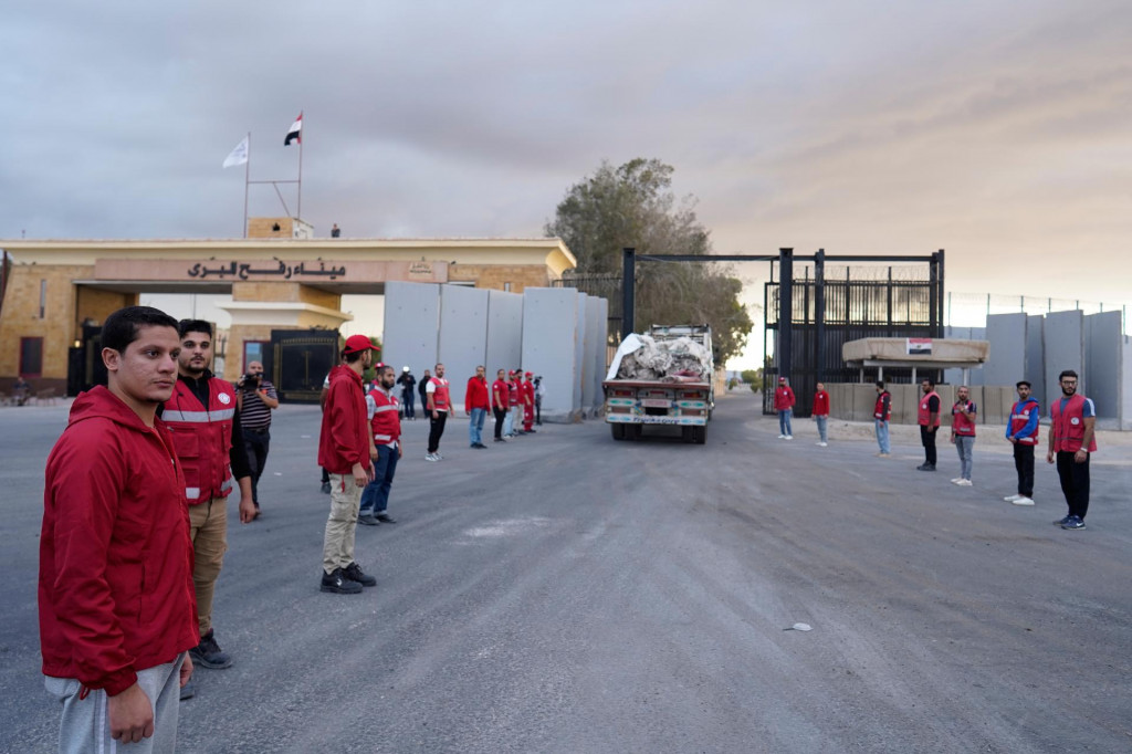 Príslušníci Egyptského Červeného kríža monitorujú kamióny vezúce humanitárnu pomoc na hraničnom priechode Rafah medzi Egyptom a Pásmom Gazy. FOTO: TASR/AP