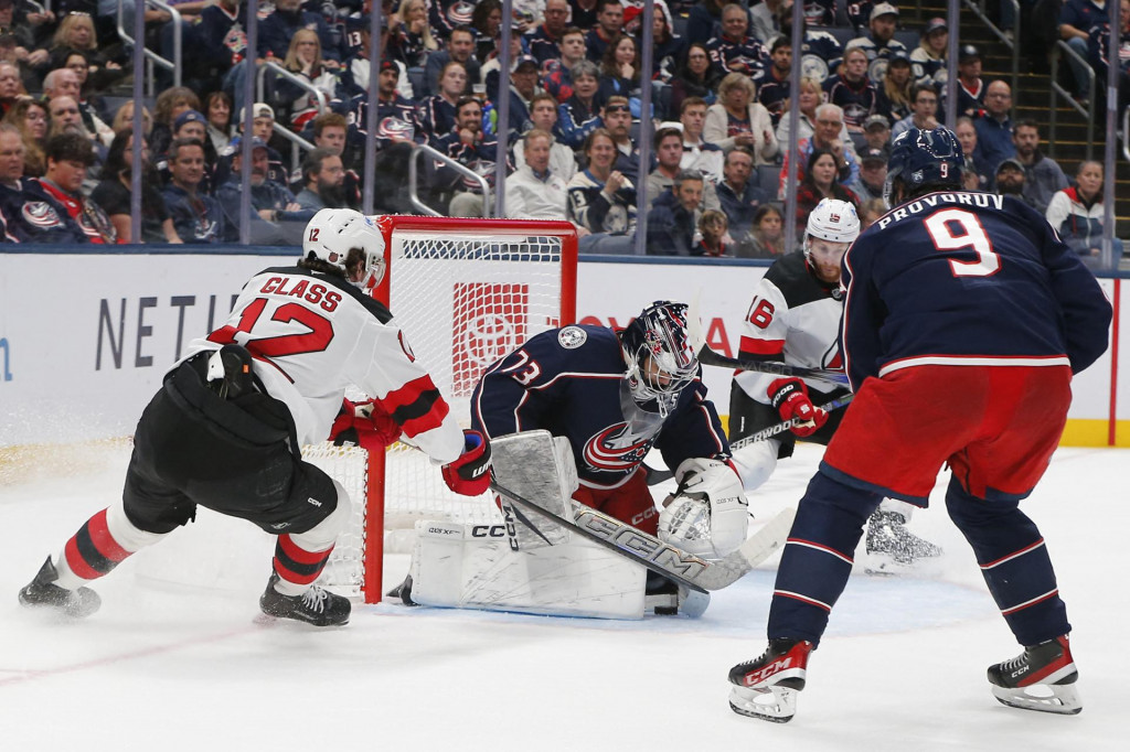 Obranca New Jersey Devils Šimon Nemec siaha po uvoľnenom puku od brankára Columbus Blue Jackets Jeta Greavesa. FOTO: Reuters/Russell LaBounty