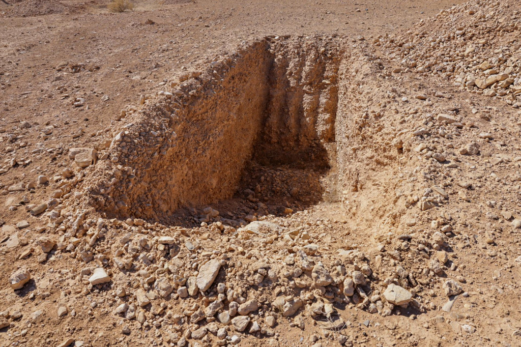 Jeden svedok agentúre Reuters povedal, že bol vykopaný nedokončený zákop na uloženie tiel v tomto masovom hrobe v púšti neďaleko východosýrskeho mesta Dhumair. FOTO: REUTERS
