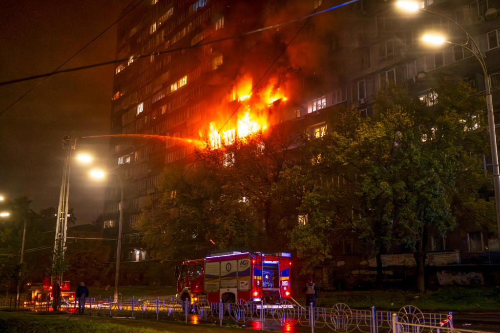 Hasiči sa snažia uhasiť požiar po leteckom útoku ruskej armády na obytnú štvrť v ukrajinskej metropole Kyjev. FOTO: TASR/AP