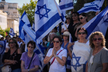 Izraelčania sa zhromažďujú pri aute vezúcom rakvu zomrelého izraelského rukojemníka Guya Illouza po jeho prepustení militantmi Hamasu v izraelskom meste Rišon Lezion. FOTO: TASR/AP