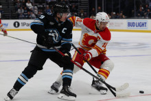 Pravé krídlo tímu Utah Mammoth Clayton Keller (9) a pivot Calgary Flames Mikael Backlund (11) bojujú o puk počas prvej tretiny v Delta Center. FOTO: Rob Gray/Imagn Images