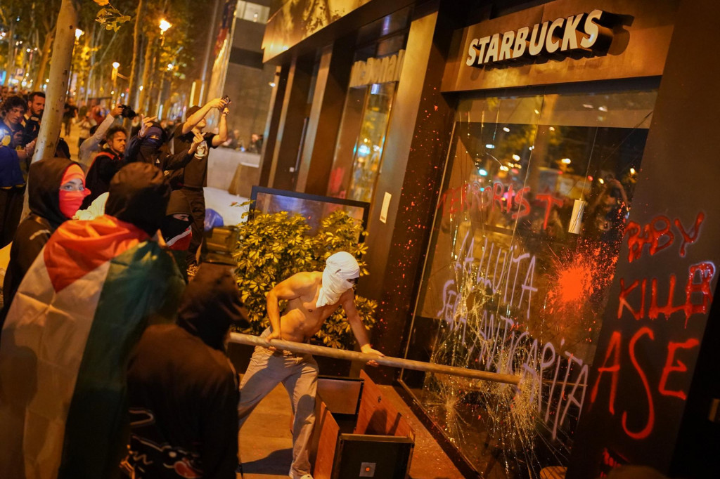 Demonštranti ničia výkladné okno kaviarenskej siete Starbucks počas pro-palestínskej demonštrácie na vyjadrenie podpory s Palestínčanmi v Gaze a proti izraelským akciám. FOTO: TASR/AP