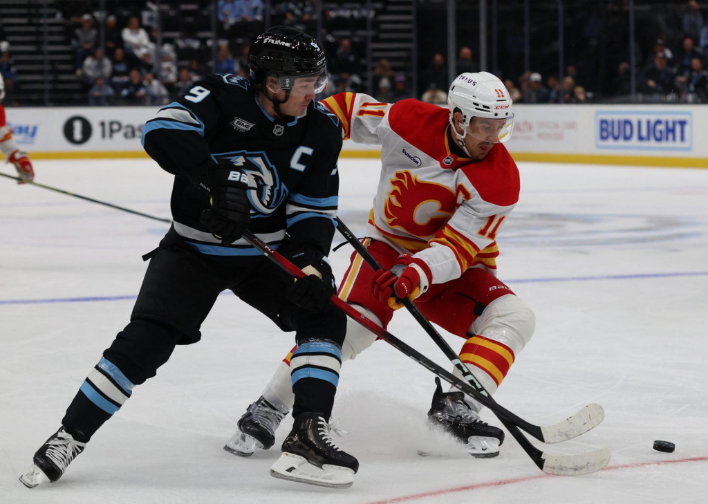 Pravé krídlo tímu Utah Mammoth Clayton Keller (9) a pivot Calgary Flames Mikael Backlund (11) bojujú o puk počas prvej tretiny v Delta Center. FOTO: Rob Gray/Imagn Images