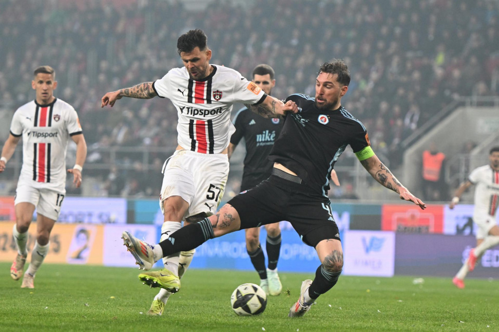 Súboj dvoch odvekých rivalov ponúka aj množstvo súbojov veľkých hráčskych osobností. V tomto prípade bojuje o loptu Trnavčan Michal Ďuriš s kapitánom Slovana Guramom Kašiom. FOTO: TASR/L. Grinaj