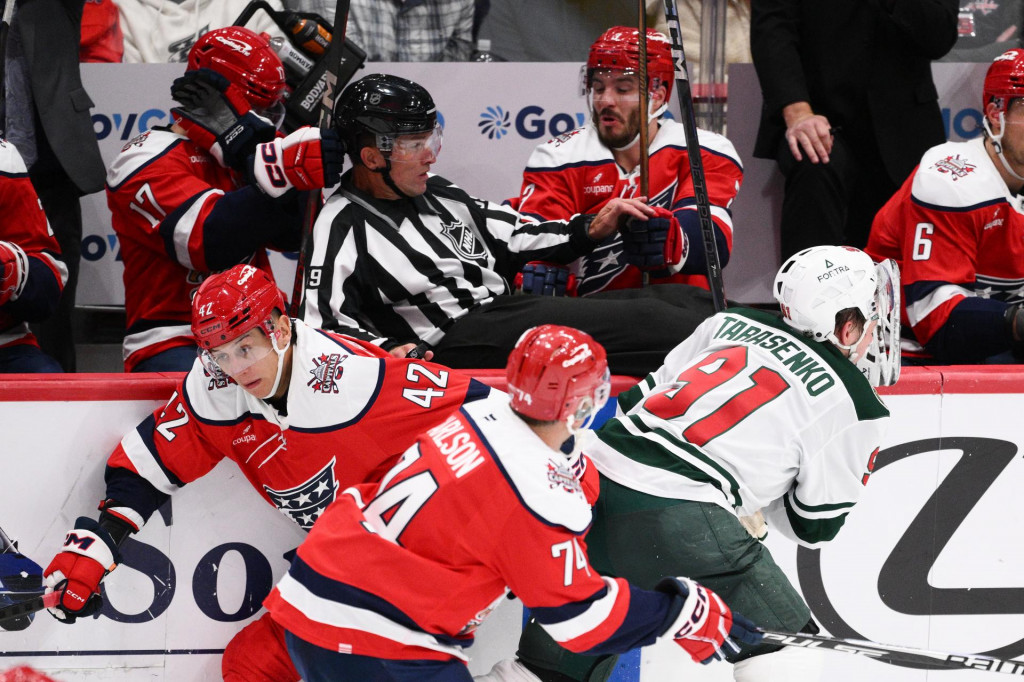 Slovenský hokejista Washingtonu Capitals Martin Fehérváry (42), čiarový rozhodca Steve Barton (uprostred), hráč Washingtonu John Carlson (74) a hráč Minnesoty Wild Vladimir Tarasenko (91) počas zápasu zámorskej NHL Washington Capitals - Minnesota Wild vo Washingtone. FOTO: TASR/AP