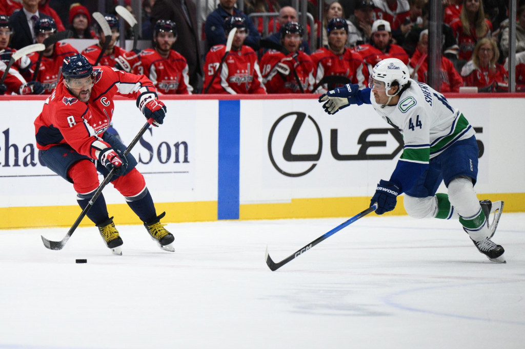 Kapitán Washingtonu Capitals Alex Ovečkin (vľavo) a hokejista Vancouveru Canucks Kiefer Sherwood bojujú o puk. FOTO: TASR/AP