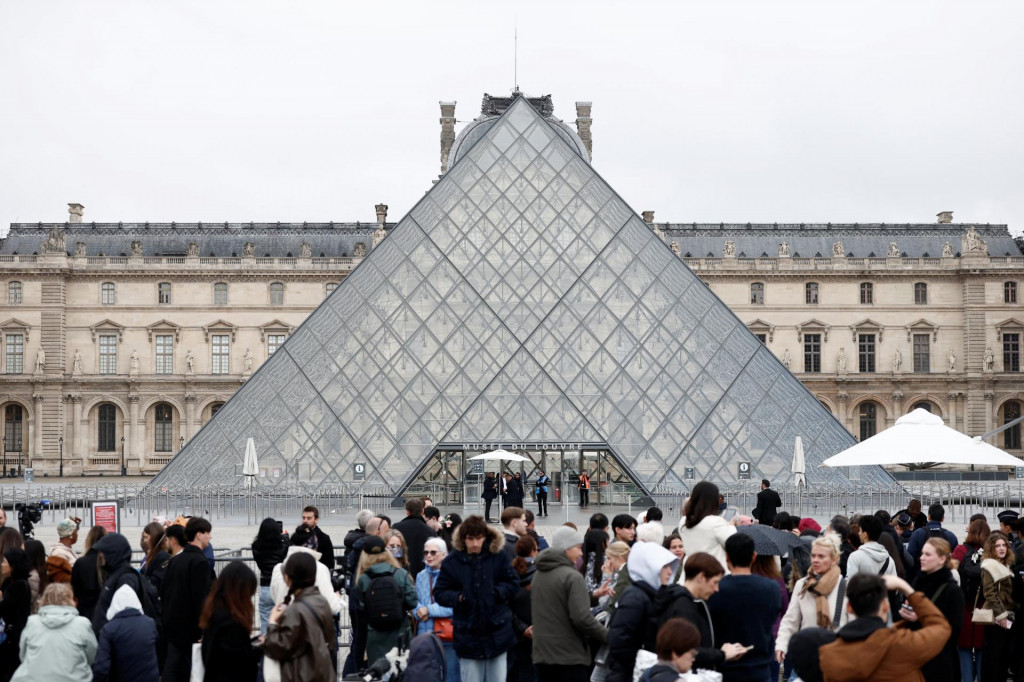 Ľudia stoja pri sklenenej pyramíde v múzeu Louvre, ktoré zostáva zatvorené deň po veľkolepej lúpeži šperkov. FOTO: Reuters