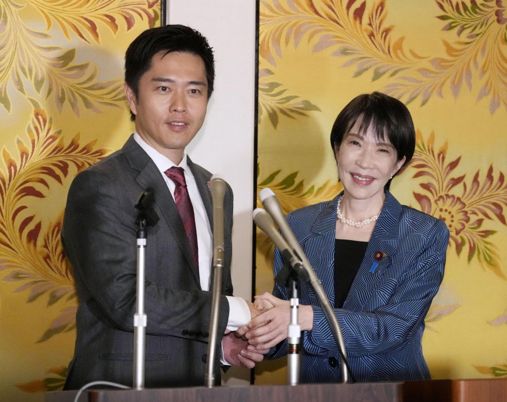 Líderka vládnucej japonskej Liberálnodemokratickej strany Sanae Takaičiová si podáva ruku s Hirofumim Jošimurom, lídrom Strany inovácií. FOTO: Reuters/Kjódó