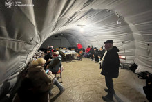 Ľudia si nabíjajú zariadenia, používajú internetové pripojenie a zohrievajú sa v centre nedobytnosti po tom, čo bola v Černihivskej oblasti na Ukrajine zasiahnutá kritická infraštruktúra. FOTO: Reuters/Štátna záchranná služba Ukrajiny