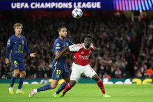 Slovenský futbalista v drese Atlética Madrid Dávid Hancko (uprostred) a hráč Arsenalu Bukayo Saka (vpravo) bojujú o loptu v zápase 3. kola ligovej fázy Ligy majstrov FC Arsenal - Atlético Madrid. FOTO: TASR/AP