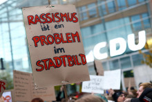 Transparent s nápisom „Rasizmus je problémom v mestských panorámach“ počas protestu proti nemeckému kancelárovi Friedrichovi Merzovi. FOTO: Reuters