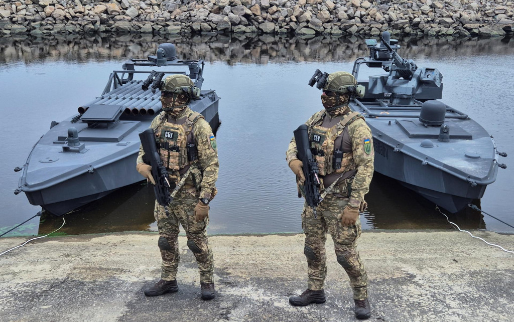 Príslušníci ukrajinskej bezpečnostnej služby stoja na stráži pri najnovších verziách námorného dronu „sea baby“. FOTO: Reuters