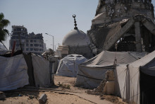 Stany v tábore pre vysídlencov medzi troskami mešity zničenej počas izraelských leteckých útokov a pozemnej ofenzívy v meste Gaza 23. októbra 2025. FOTO: TASR/AP
