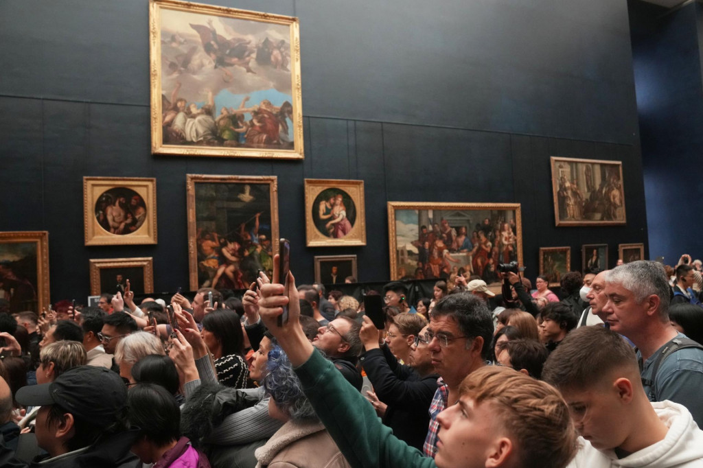 Na snímke ľudia počas návštevy parížskeho múzea Louvre, tri dni po krádeži šperkov v stredu 22. októbra 2025. FOTO TASR/AP