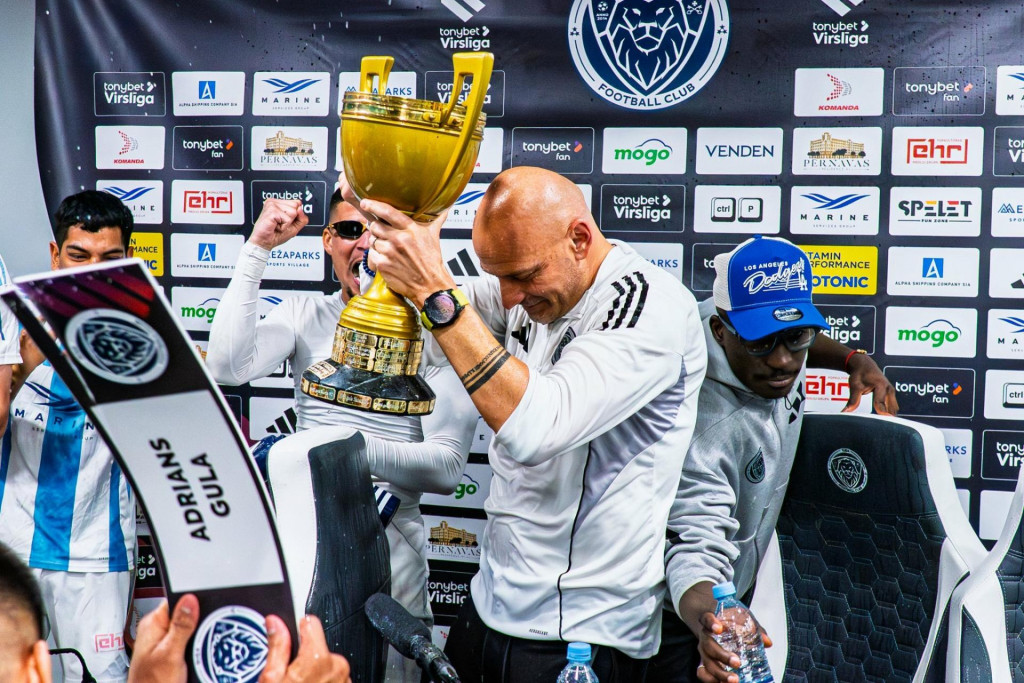 Ako už býva zvykom pri zisku titulu, aj Guľu jeho rozradostení zverenci „prepadli“ počas pozápasovej tlačovej konferencie. FOTO: Facebook (Riga Football Club)