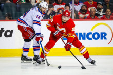 Ľavé krídlo Calgary Flames Samuel Honzek a pravé krídlo New York Rangers Taylor Raddysh bojujú o puk. FOTO: Reuters