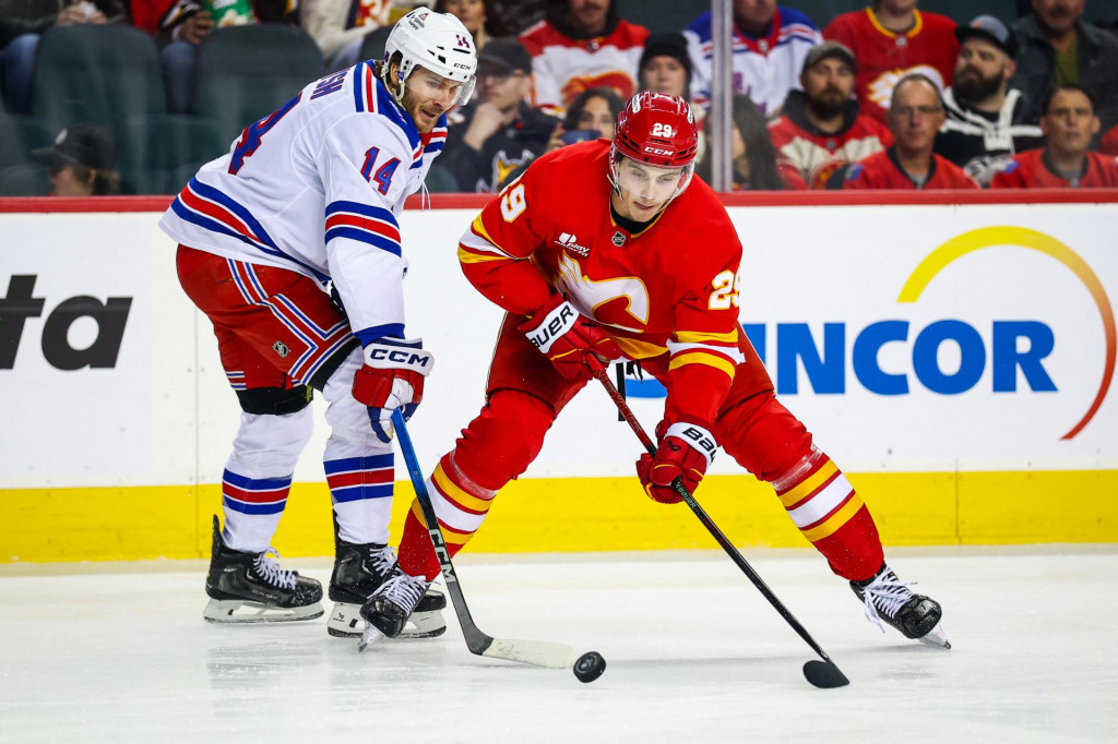 Ľavé krídlo Calgary Flames Samuel Honzek a pravé krídlo New York Rangers Taylor Raddysh bojujú o puk. FOTO: Reuters