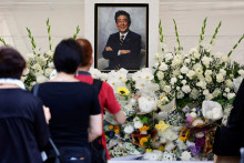 Smútiaci pokladajú kvety za zosnulého japonského expremiéra Šinzóa Abeho. FOTO: Reuters