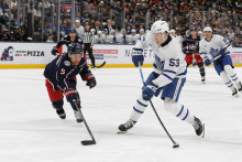 Pravé krídlo tímu Toronto Maple Leafs Easton Cowan (53) vystrelil zápästím na bránu, zatiaľ čo obranca tímu Columbus Blue Jackets Denton Mateychuk (5) bránil počas tretej tretiny. FOTO: Russell LaBounty/Imagn Images
