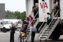 Prvá skupina bielych juhoafrických utečencov vystupuje z „prepravného vozidla“ po prílete na medzinárodné letisko Dulles v Dulles v štáte Virgínia v USA. FOTO: Reuters