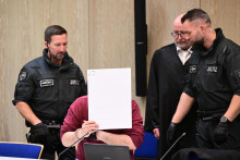 40-ročný nemecký občan Alexander S., ktorý 3. marca vrazil svojím autom do účastníkov karnevalového sprievodu v Mannheime, si zakrýva tvár po začatí procesu v súdnej sieni v Mannheime. FOTO: TASR/DPA