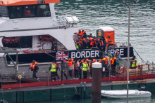 Ľudia, pravdepodobne migranti, vystupujú z plavidla britských pohraničných síl pri príchode do prístavu Dover v Doveri v Británii. FOTO: Reuters