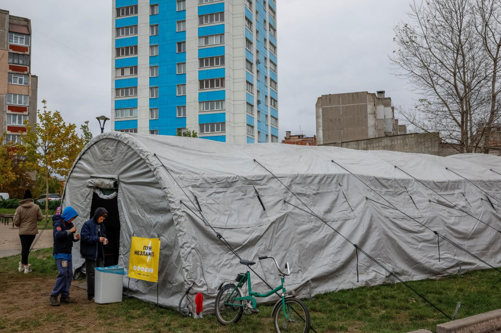 Ľudia sa zhromažďujú okolo centra, kde môžu využívať internetové pripojenie, nabíjať si zariadenia a zohriať sa uprostred výpadku dodávok vody a elektriny po zasiahnutí kritickej infraštruktúry. FOTO: REUTERS
