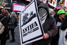 Demonštrant drží transparent s nápisom „antifa“ na proteste „Žiadni králi“ proti politike amerického prezidenta Donalda Trumpa na Times Square v New Yorku. FOTO: Reuters