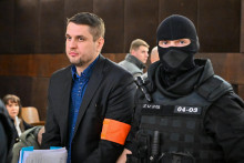 Vľavo obžalovaný Adam Puškár prichádza v sprievode príslušníkov Zboru väzenskej a justičnej stráže na hlavné pojednávanie v kauze vraždy Daniela Tupého. FOTO: TASR/Pavol Zachar