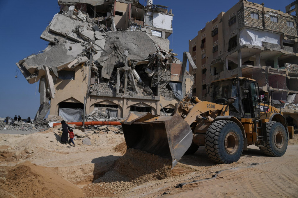 Členovia militantnej skupiny Hamas hľadajú telá izraelských rukojemníkov pod troskami zničených budov v meste Chán Júnis, na juhu Pásma Gazy. FOTO: TASR/AP